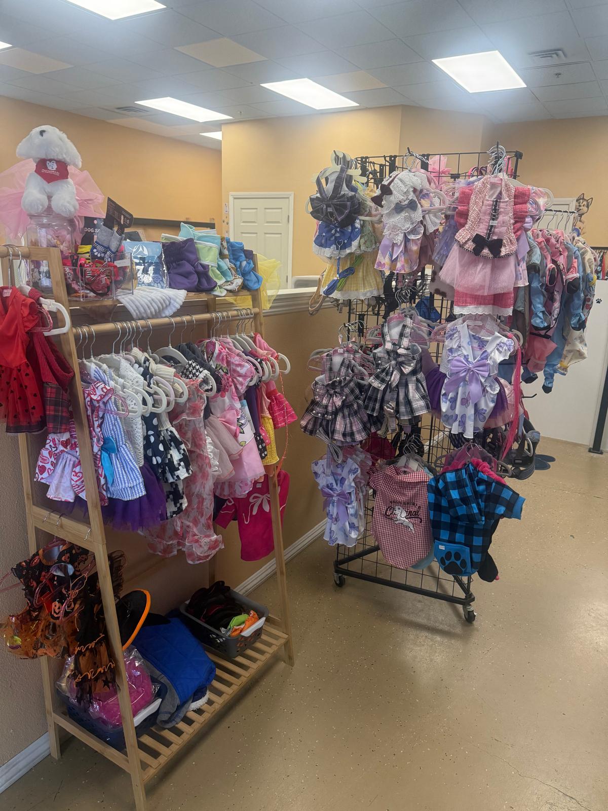 Tails Spa & Boutique pet clothing and accessories display with stylish outfits on racks